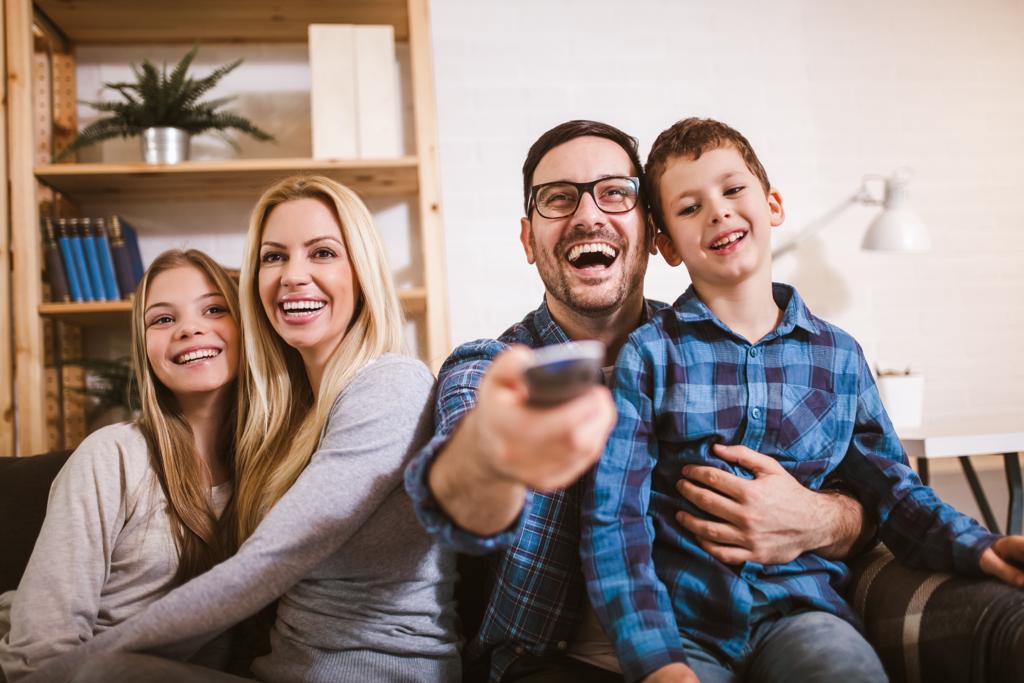 Família feliz assistindo tv